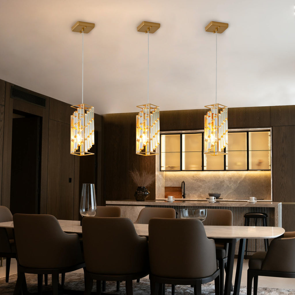 An elite crystal prism design pendant trio casting a glamorous, multi-faceted warm light across an upscale room.