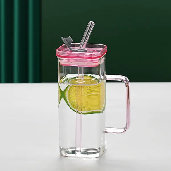 Main Product Image: ChromaCuvette pink glass straw cup with matching lid on a wooden office desk.