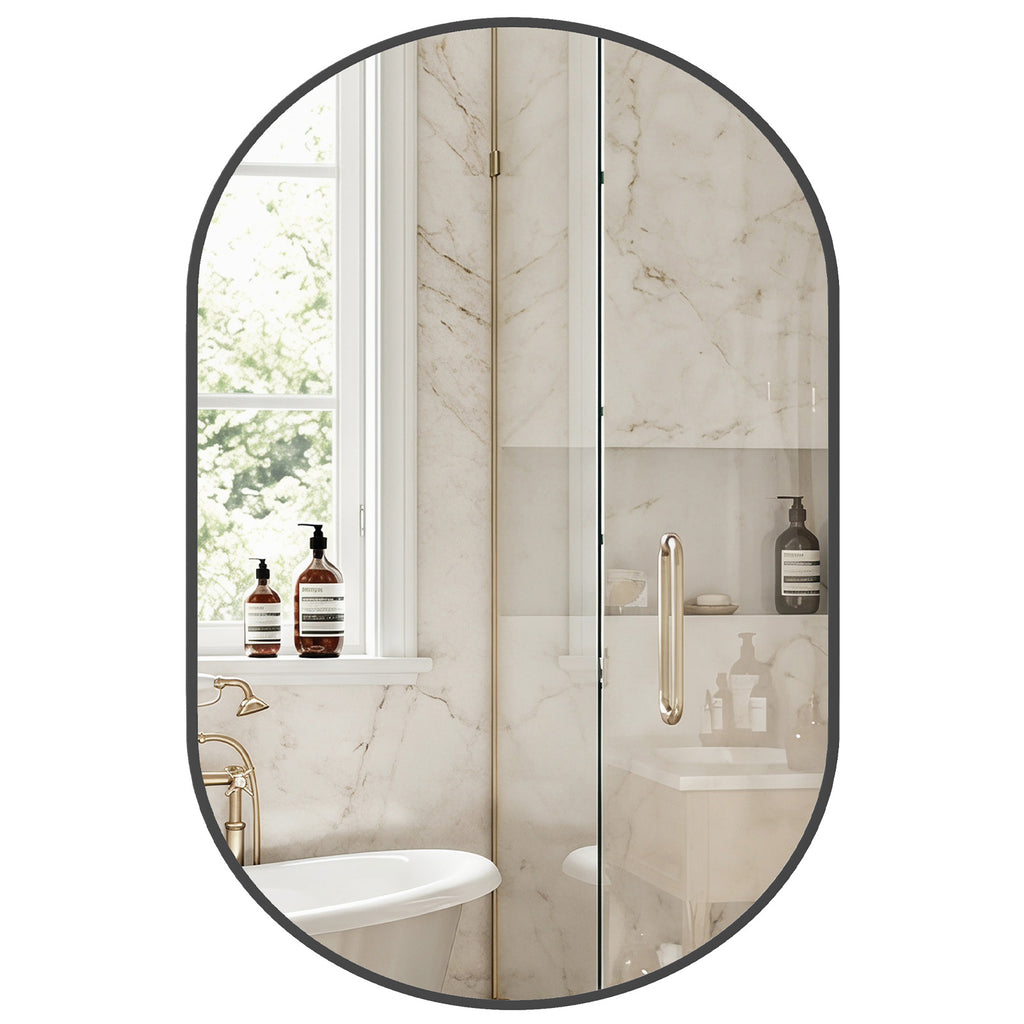 Aura matte black oval wall mirror mounted vertically in a minimalist modern bathroom